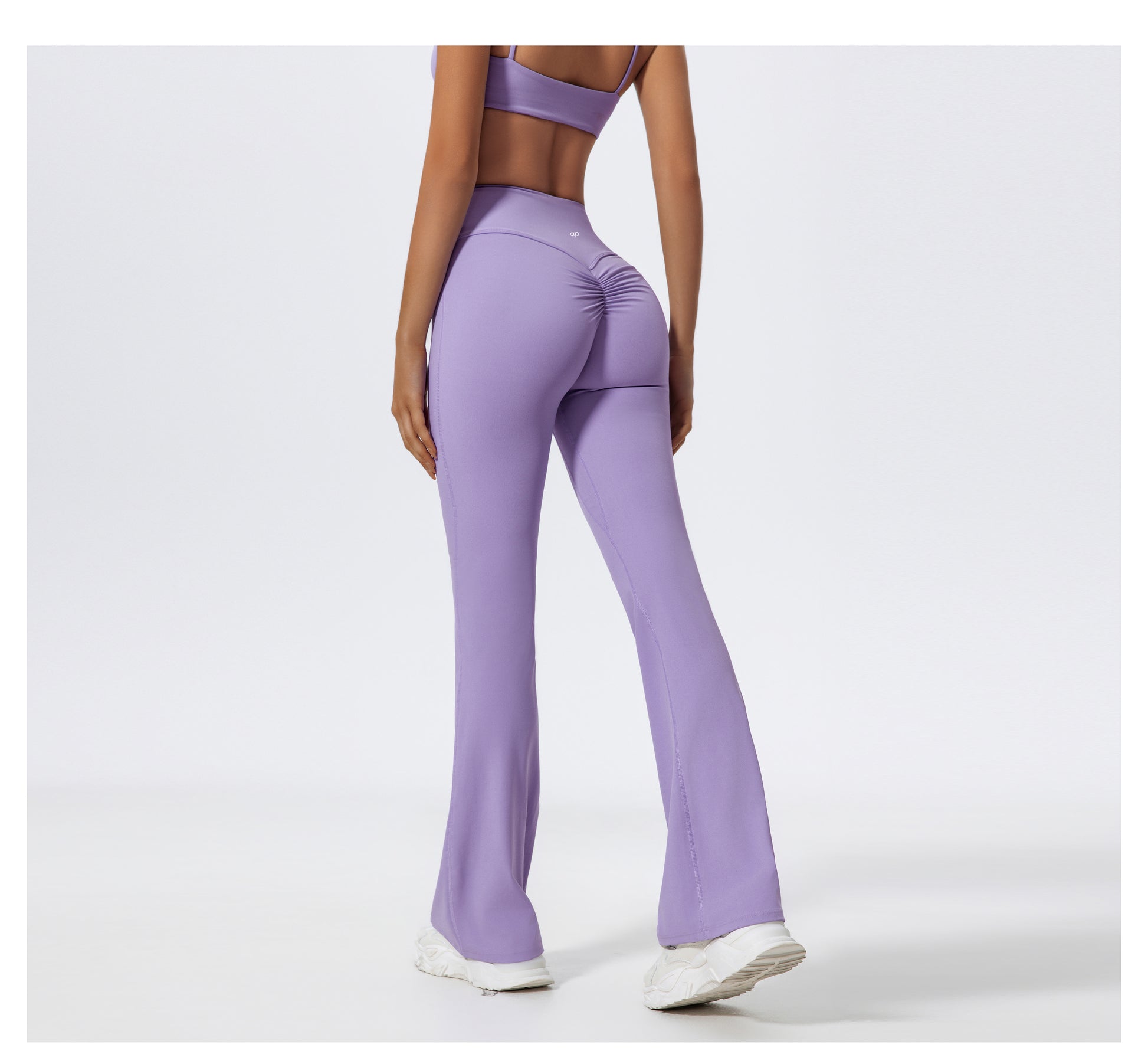 Person wearing purple flared leggings on a white background