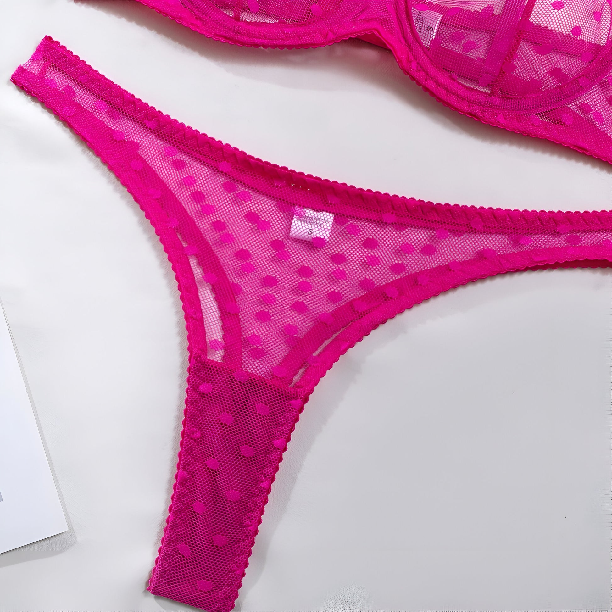 Pink lace lingerie set on a white background